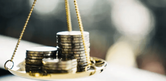 Piles de pièces de monnaie sur une balance, représentant les coûts et la gestion de la paie.
